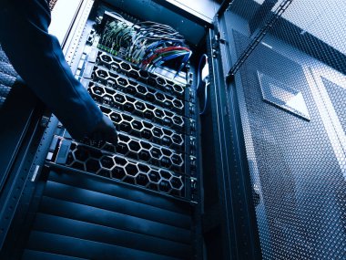 A close-up view of a server rack filled with intricate network cables and components, highlighting the technology behind data management and storage systems.