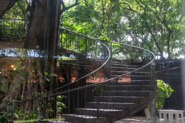 Modern kıvrımlı bir merdiven yemyeşil bir ortamda esiyor. Doğanın güzelliği ve sükunetiyle uyumlu zarif bir mimari sergiliyor..