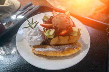 Dondurma, taze meyve ve çikolata serpiştirilmiş sıcak bir pastanın yer aldığı nefis bir tatlı..