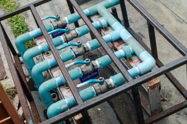 Bu görüntü, endüstriyel ortamlarda kullanılan tesisat bileşenlerini vurgulayan metal bir iskelet üzerinde sıralanmış mavi su borularını gösteriyor. İnşaatla ilgili projeler için ideal.