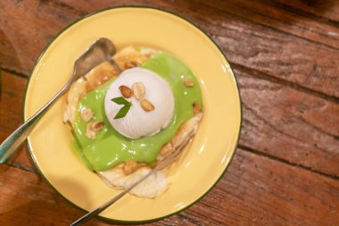 Muz ve fındıklı yeşil bir sosun üstünde bir kepçe dondurma bulunan ağız sulandıran bir tatlı. Her durum ya da mutfak macerası için mükemmel..