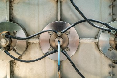 Kablo bağlantılarının yer aldığı metalik bileşenlerin yakın plan görüntüsü, endüstriyel makinelerdeki karmaşık tasarım ve mühendisliği vurguluyor.