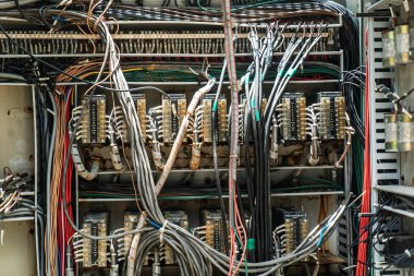 Modern devre ve teknolojinin endüstriyel ortamlardaki karmaşıklığını gösteren elektrik panelindeki kabloların ve bileşenlerin karmaşık bir düzeni..