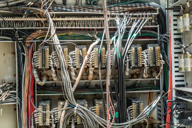 Elektrik panelinin birbirine bağlı kabloları ve devre kesicileri gösteren karmaşık bir görüntüsü modern elektrik sistemlerinin karmaşıklığını ve bakımını vurguluyor..