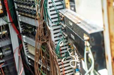 Elektrik kabloları ve devre kartlarından oluşan karmaşık bir düzenleme yakın plan görüntüsü. Bu resim modern makine ve elektronikte bulunan karmaşık teknolojiyi gösteriyor.