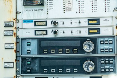 Endüstriyel kontrol panelinde göstergeler, düğmeler ve çeşitli göstergeler var. Bu görsel aletler klasik bir estetik ve karmaşık bir tasarıma sahip teknoloji ekipmanlarını sergiliyor..