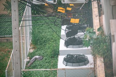 Karışık kablolarla çevrili havalandırma ünitelerinin hava görüntüsü, şehir ortamında kentsel altyapı ve teknoloji sergileniyor.