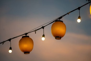 Çok güzel yanan fenerler alacakaranlıkta asılı, sıcak ve davetkar bir atmosfer yaratıyor etkinlikler ve toplantılar için mükemmel. Kültürel ve şenlikli konular için ideal.