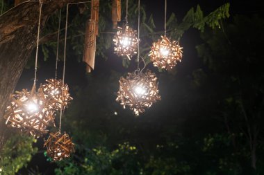 Büyüleyici bambu fenerler ağaçtan sarkıyor ve geceleri sıcak ve davetkar bir atmosfer yaratıyor. Kırsal tasarım dış mekanlara güzellik katıyor..