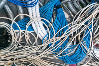 Renkli elektrik kabloları ve kablolarından oluşan kaotik bir düzenleme, endüstriyel ortamlardaki modern kablo tesislerinin karmaşıklığını gözler önüne seriyor..