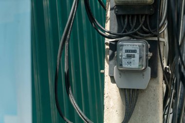 Elektrik sayacı elektrik dağıtımı için çeşitli kablo ve kabloların yanı sıra açık hava ortamında enerji kullanım değerlerini görüntüler..
