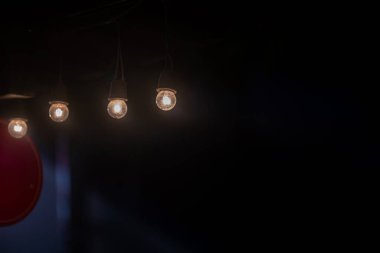 Karanlık bir zemin üzerinde yumuşak parlak ışıklar barındıran sakin bir görüntü, rahat iç mekanlar veya sanatsal tasarımlar için mükemmel davetkar bir atmosfer yaratıyor..