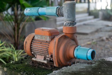 Bir su pompası motor vitrinine yakın çekim. Makinelerin karmaşık detayları. Bu resim bir açık hava ortamında endüstriyel tasarım ve işlevselliği vurgular.