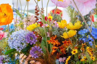 Çeşitli renkli çiçeklerin yer aldığı canlı bir çiçek aranjmanı, parlak taç yaprakları ve yemyeşil, bahar veya yaz süslemeleri için mükemmel..