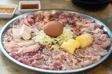 Taze kesikler, yumurta ve lahana içeren canlı bir çiğ et tabağı. Lezzetli yemek pişirme tekniklerini keşfetmeye hazır aşçılar için mükemmel..