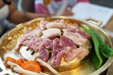 Canlı sebzelerle çevrili taze et parçaları ızgara tabağında duruyordu. Bu cezbedici sahne birlikte yemek pişirmenin ve yemek yemenin zevkini yakalar..