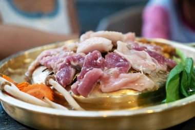 Taze sebzelerle çevrili, ızgaraya hazır taze et parçalarının canlı bir gösterisi, yemek pişirme ve ortak yemek deneyimlerini gözler önüne seriyor..