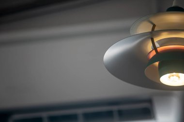 Modern bir kolyenin yakın plan görüntüsü benzersiz bir tasarım ve sıcak aydınlatma sergiliyor. İç dekorasyon için mükemmel ilham ve aydınlatma fikirleri.