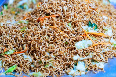 Taze sebzelerle karıştırılmış baştan çıkarıcı yakın plan erişteler. Yemek blogcuları, yemek üreticileri ve aşçılık meraklıları için ideal..