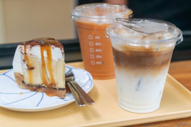 Cazip bir dilim kek iki ferahlatıcı içkinin yanında oturur ve her tatlı aşığı için mükemmel bir kahve molası sahnesi yaratır. Bu lezzetli anın tadını çıkar.!