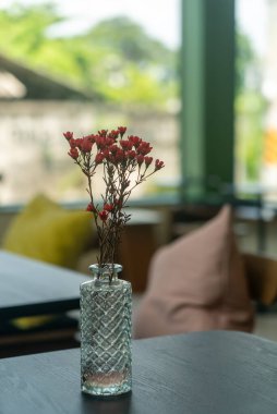 A beautiful floral arrangement featuring delicate flowers in a textured glass vase, adding a touch of elegance and tranquility to a cozy interior space.