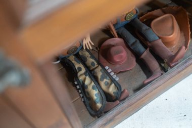 This image showcases a vintage cowboy toy figurine displayed with unique accessories, evoking childhood nostalgia and playful imagination in a charming setting.