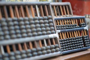 This image features a vintage wooden abacus arranged on a table, showcasing its intricate design and historical significance as a manual counting tool used for education and calculation.