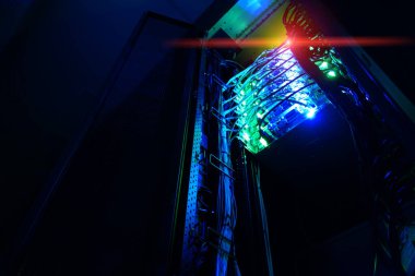 Düzenli kablolar ve gelişmiş ağ teknolojisiyle aydınlatılmış sunucu raflarını gösteren bir veri merkezinin ayrıntılı görünümü, modern bilgi altyapısının özünü yakalıyor.