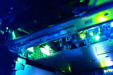 Close-up view of modern computer hardware with vibrant neon blue lights illuminating the intricate circuitry, showcasing technology and innovation in digital systems.