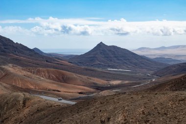 Fuerteventura 'daki çorak volkanik vadiden geçen uzak bir yol.