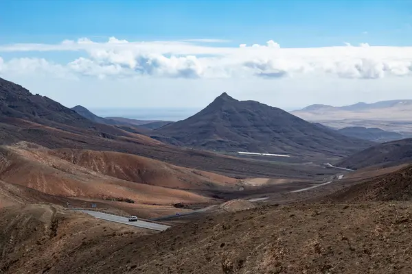 Fuerteventura 'daki çorak volkanik vadiden geçen uzak bir yol.