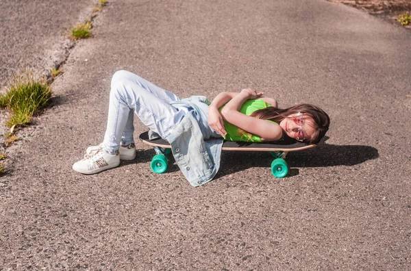 公園で晴れた日にスケートボードを楽しむ少女がいます — ストック写真