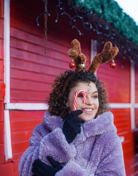 Uśmiechnięta Kobieta Kręconymi Włosami Trzyma Cukierki Świątecznym Tle Bożego Narodzenia — Zdjęcie stockowe