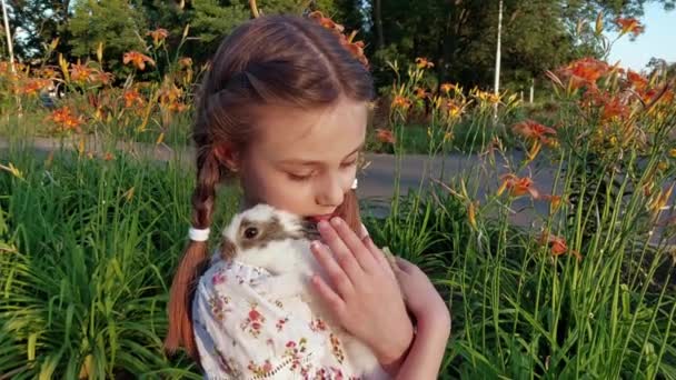 可愛いです女の子保持A赤ちゃんウサギ屋外 — ストック動画