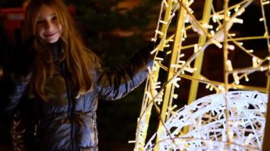 Küçük tatlı bir kızın Noel ışıklarında pazarda eğlendiği yavaş çekim videoları.