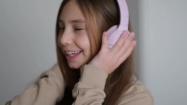 Evde müzik dinleyen bir çocuğun olduğu yavaş çekim videosu, gülümseyen küçük bir kız müzikle eğleniyor, uzun saçlı şirin bir çocukla dans ediyor.