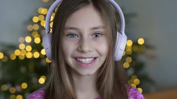 一个孩子在家听音乐的慢动作视频 一个微笑的小女孩听音乐很开心 一个长着长发的可爱的孩子跳舞 — 图库视频影像
