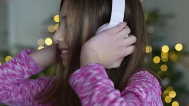一个孩子在家听音乐的慢动作视频 一个微笑的小女孩听音乐很开心 一个长着长发的可爱的孩子跳舞 — 图库视频影像
