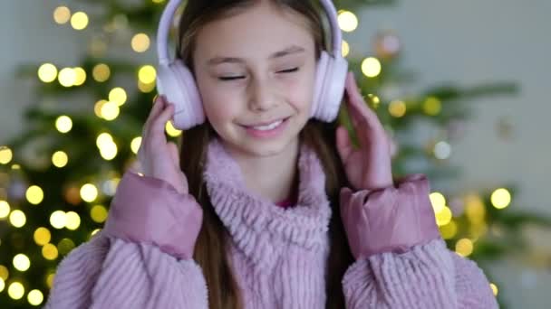子供が自宅で音楽を聞いているとスローモーションビデオ 笑顔の女の子は音楽と楽しいです 長い髪でかわいい子供を踊ります — ストック動画