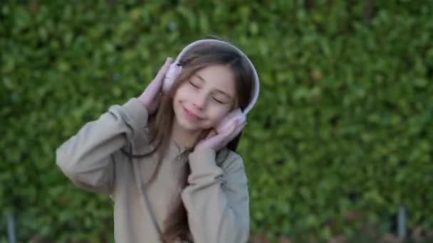 Ребенок Слушает Музыку Открытом Воздухе Улыбаясь Маленькая Девочка Весело Проводит — стоковое видео
