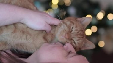 Woman huging red cat at home, gentel friendship between cat and woman