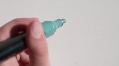 child writing on a notebook with acrylic marker