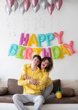 Mutlu genç aile evde doğum günü partisi veriyor.