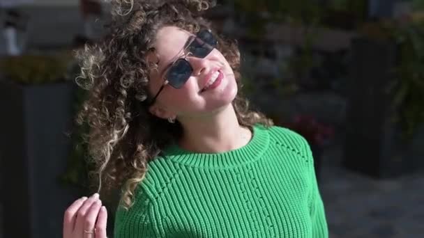 Танцующая Модная Молодая Женщина Кудрявыми Волосами Свитере Темных Солнцезащитных Очках — стоковое видео