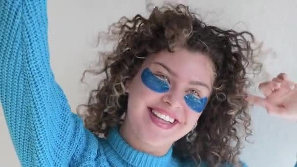 Mooie Glimlachende Jonge Vrouw Met Krullend Haar Met Ooglapjes Thuis — Stockvideo