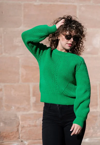 緑のセーターを着た若いファッショナブルな女性が街を歩き回り ストリートファッションのコンセプト — ストック写真
