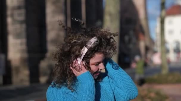 Женщина Вьющимися Волосами Голубом Свитере Танцует Наушниками Улице — стоковое видео