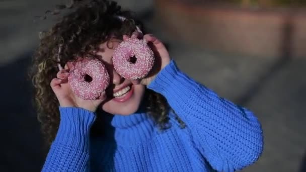 Kıvırcık Saçlı Açık Havada Donut Tutan Komik Bir Genç Kadın — Stok video