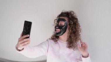 Yüzünde maske olan komik kadın evde eğleniyor.