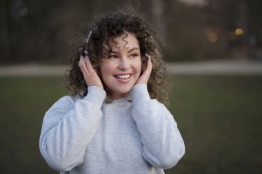 Kulaklıklı olumlu genç bir kadın müzikten hoşlanıyor. 